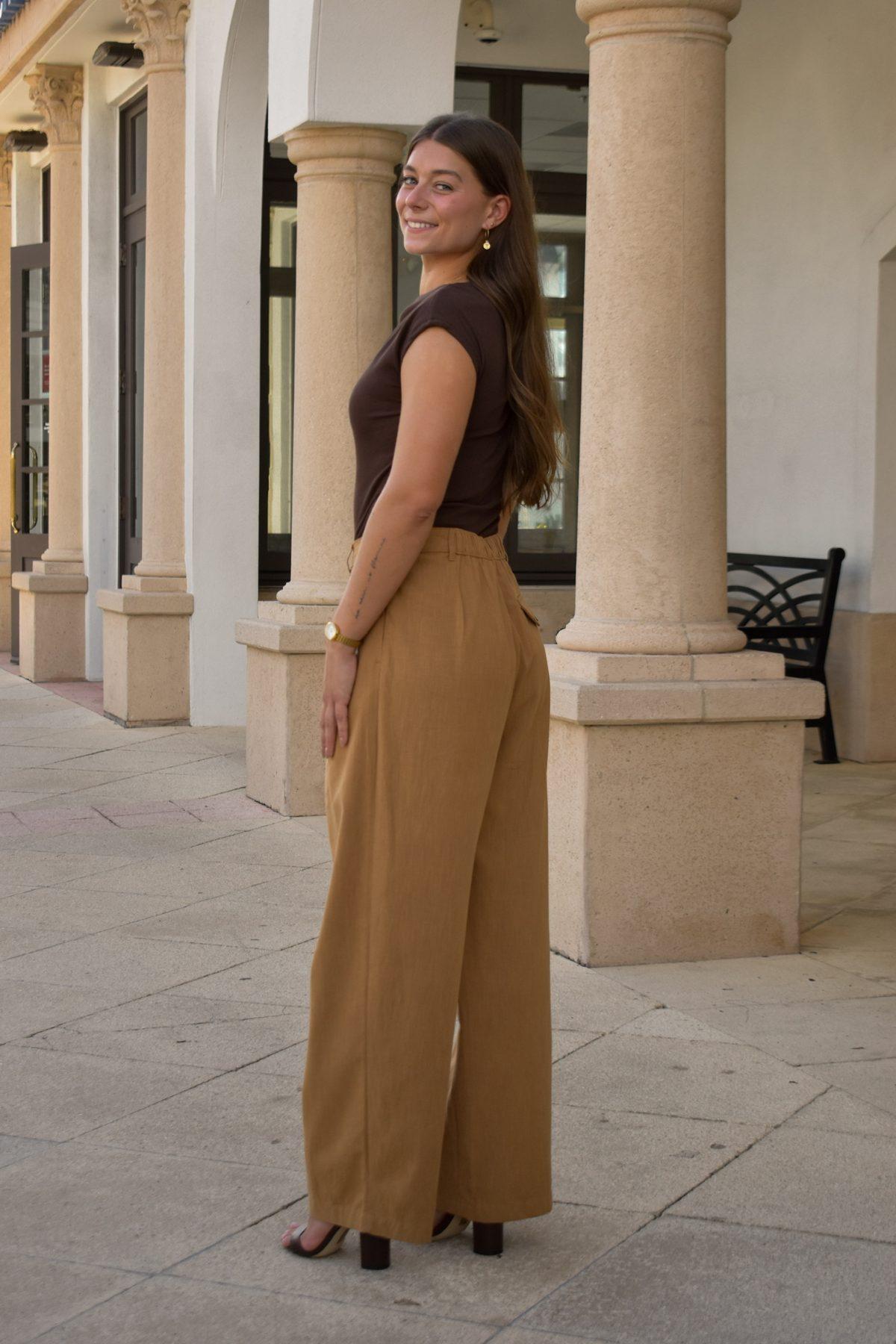 Simone Kohl walking through a sunlit colonnade